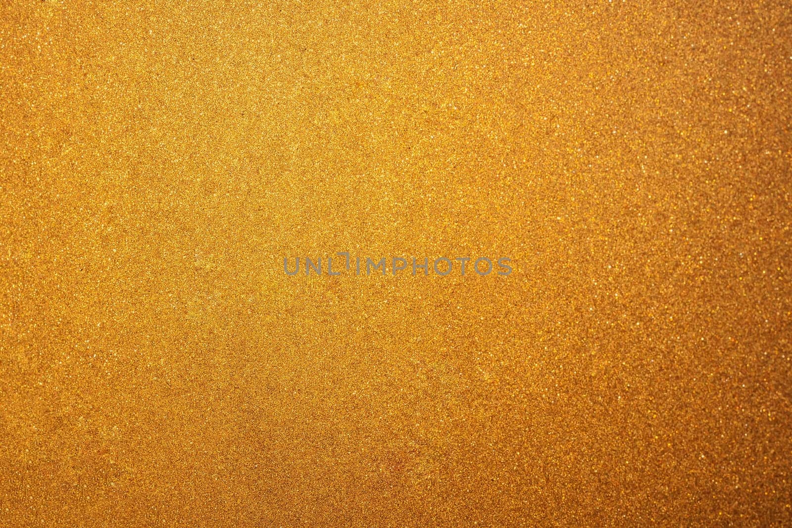 Abstract glittering golden or yellow dust or sand background with blur edges of image