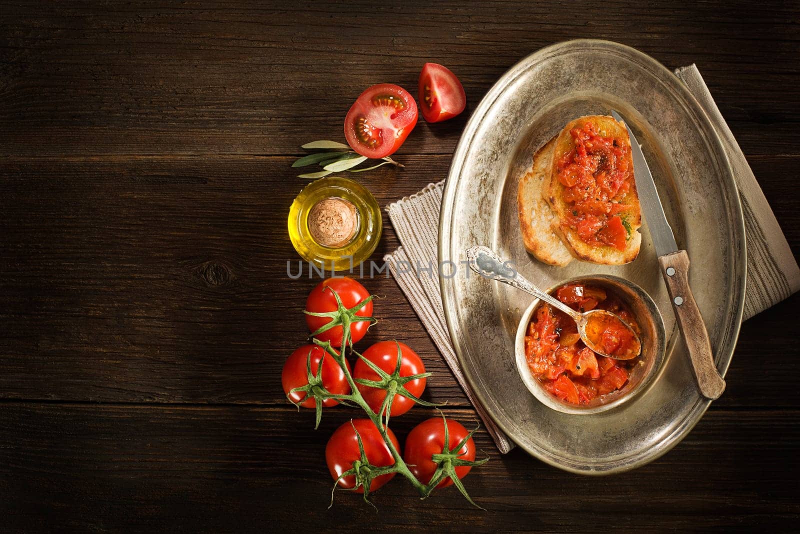 Toasted bread with tomato and olive oil on wooden background.