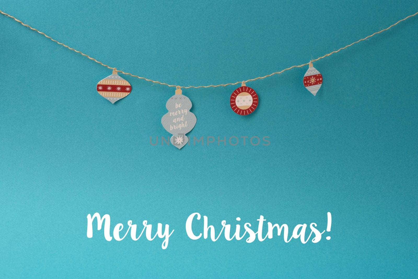Merry Christmas background. Vintage paper hand made xmas decoration ornament labels hanging on string.