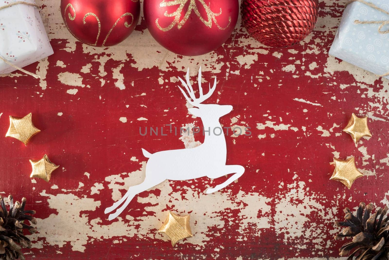 Merry Christmas Happy New Year top view greeting card background with paper deer silhouette and holiday decoration elements on vintage grunge wood texture.