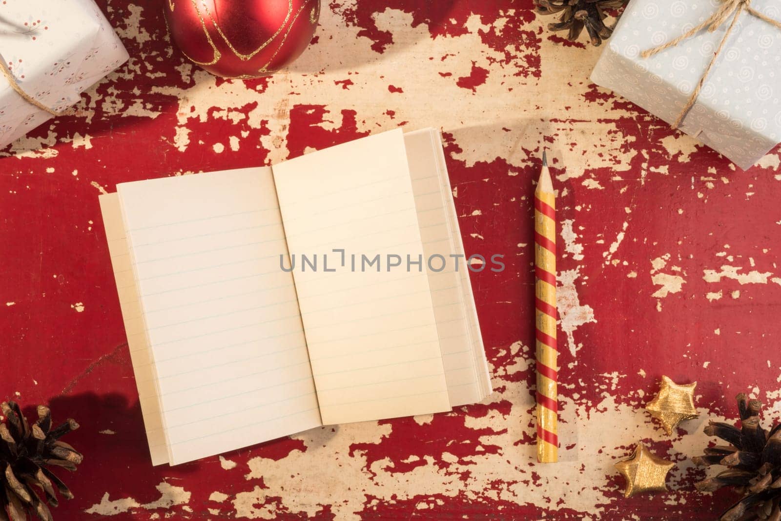 Holiday concept, top view empty paper notebook with pencil and vintage hipster Christmas ornament decoration on grunge wood texture background.