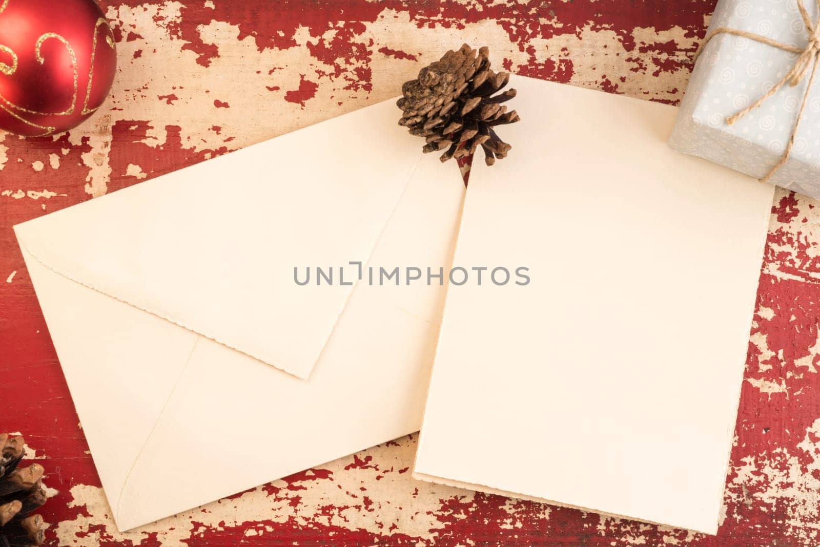 Christmas concept, top view empty greeting card envelope template with pine cone and holiday decoration on vintage grunge wood texture background.