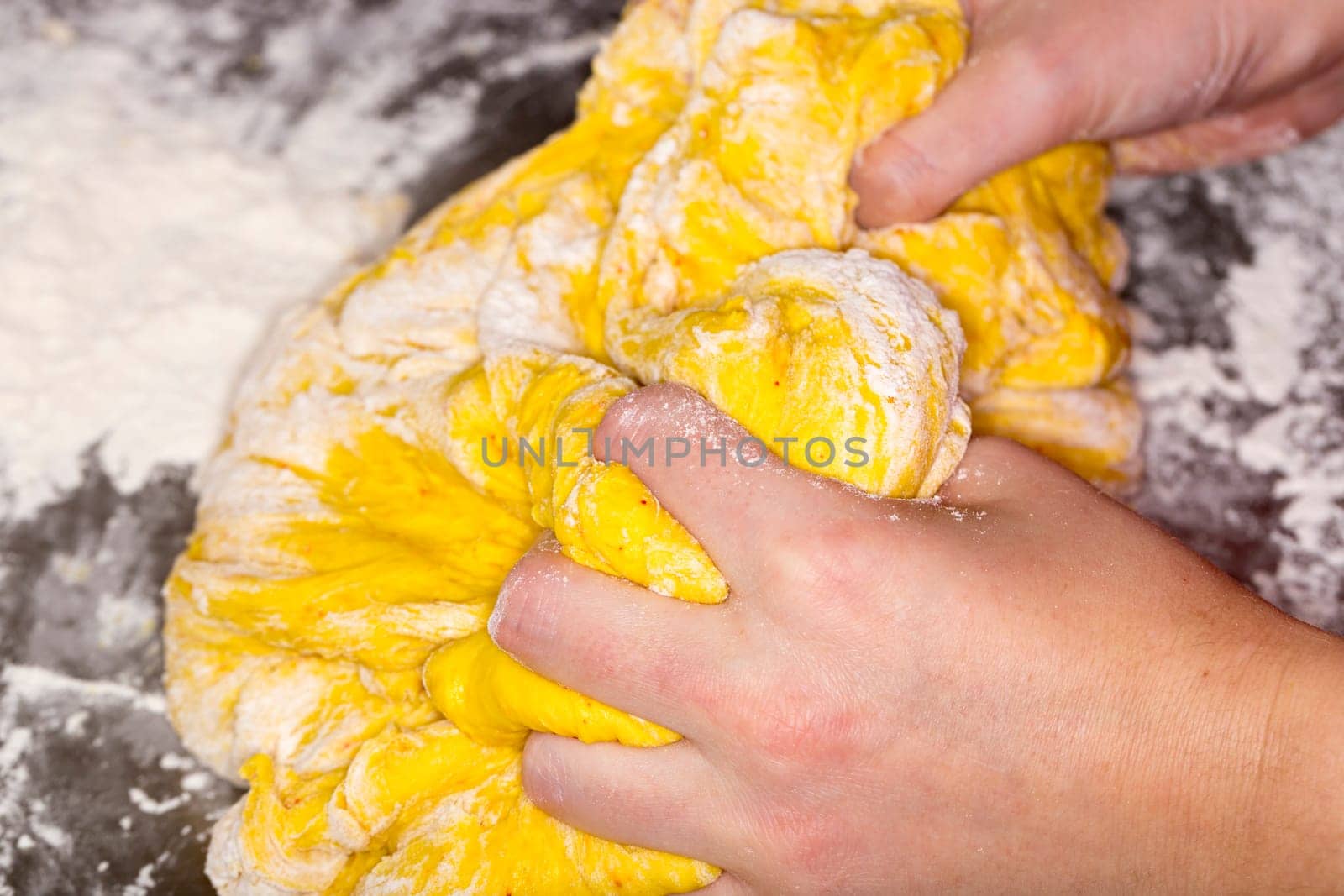 Hands in Saffron Bun Dough close up image.
