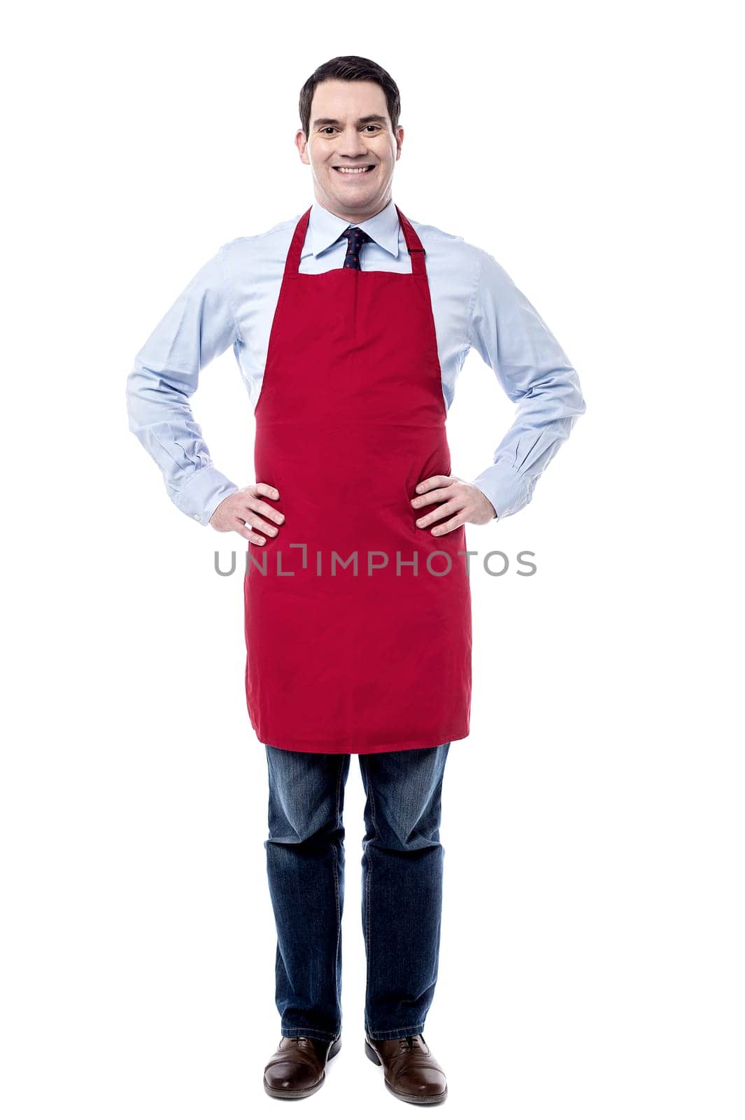 Male executive wearing apron and posing with hands on waist
