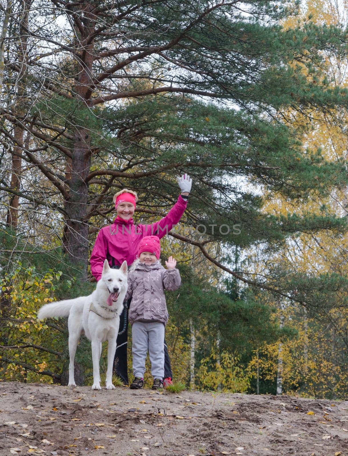 Granny with her granddaughter and a dog walk in autumn Park