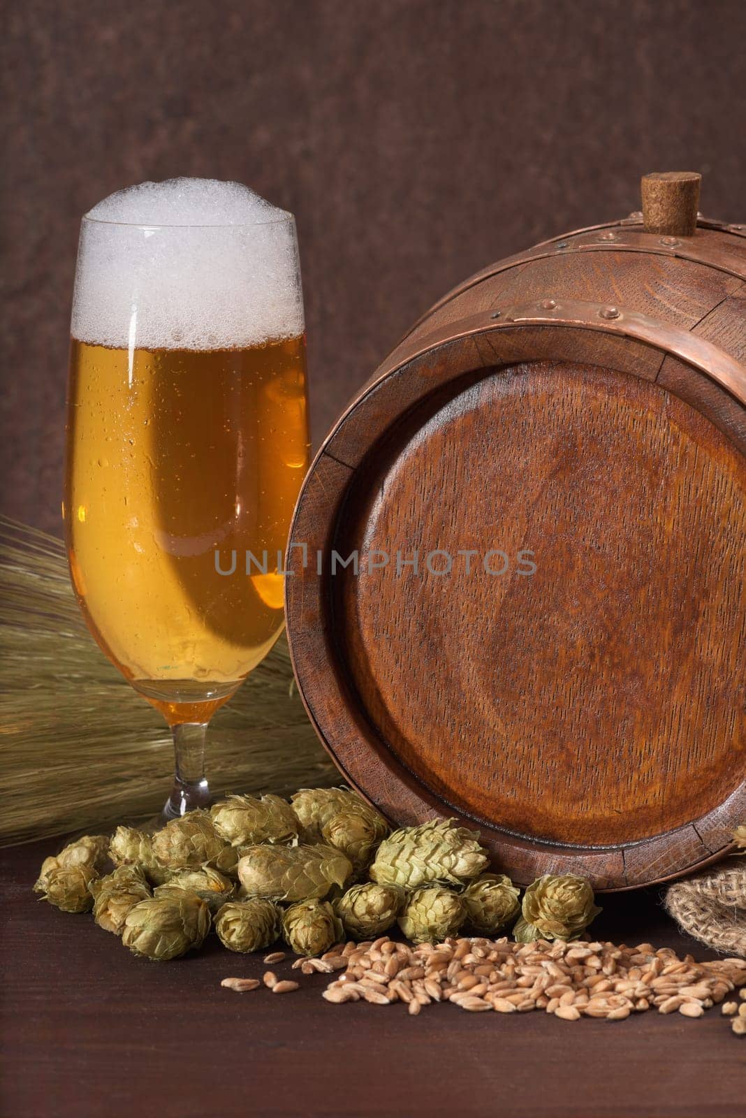 Old wooden barrel with beer glass,wheat,barley,hops and malt