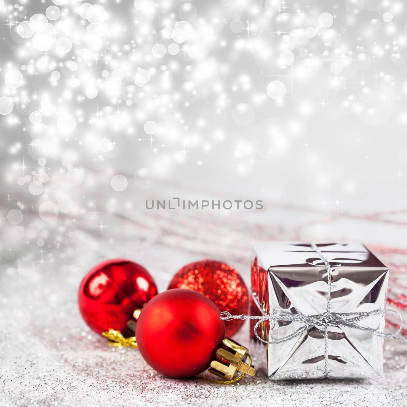 Christmas balls and ornaments in front of glittering background
