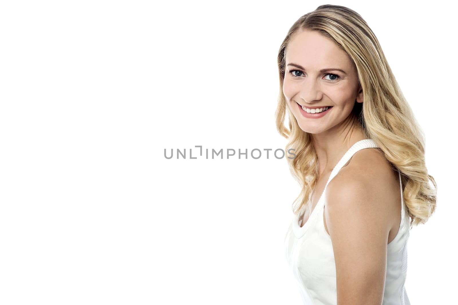 Smiling pretty girl posing sideways  to camera against white background