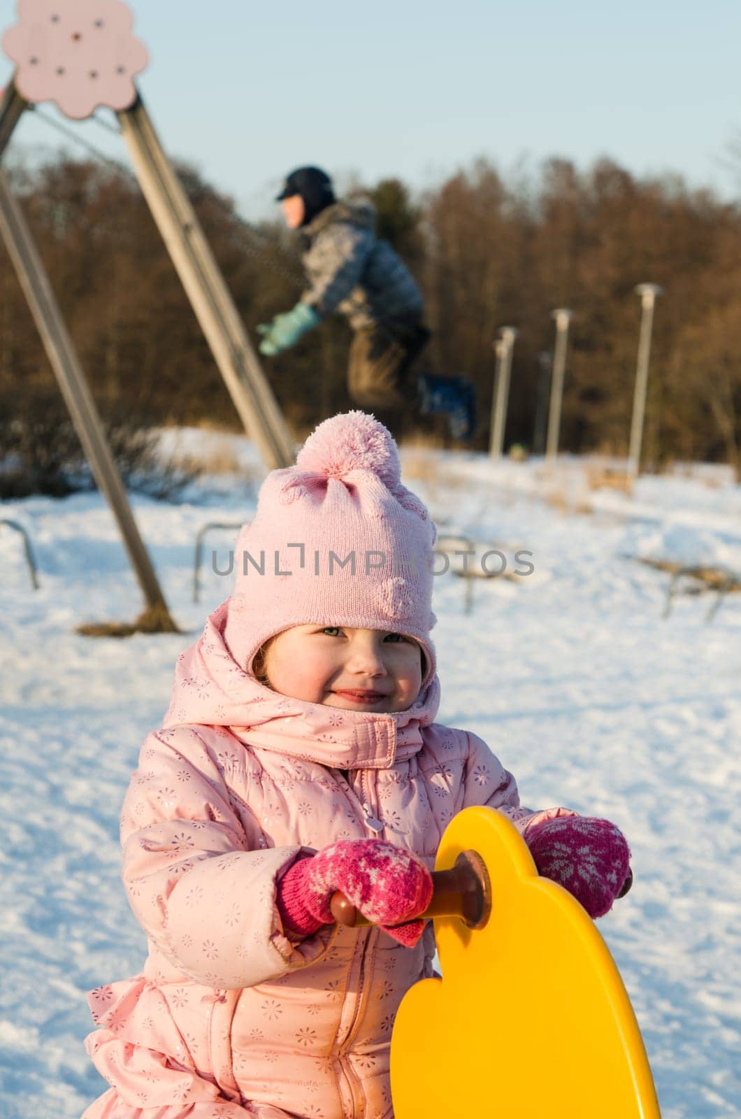 Children swinging on a swing in winter