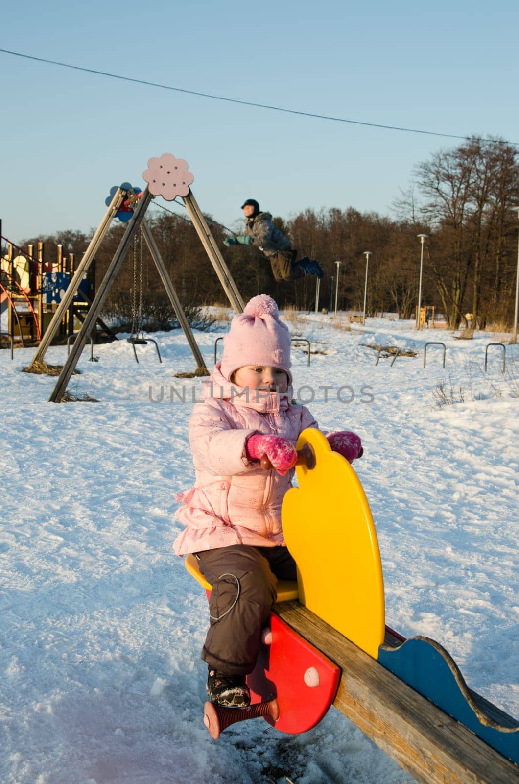 Children swinging on a swing in winter