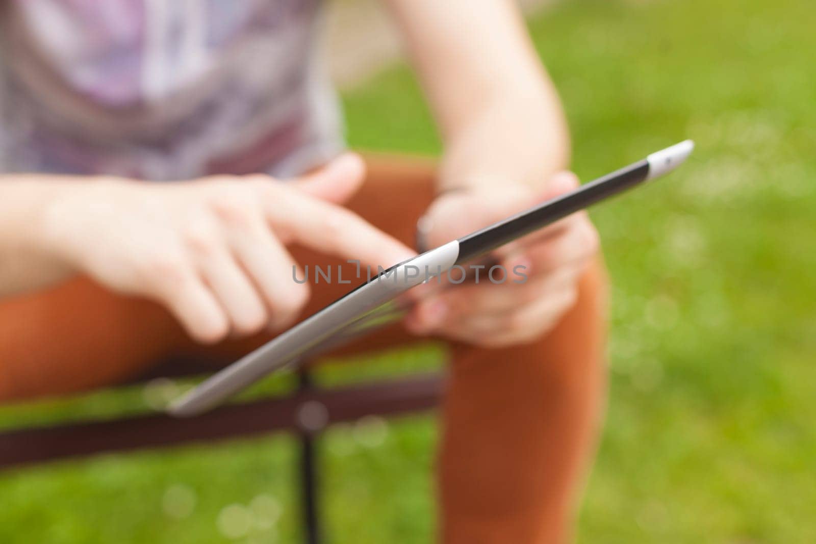 Young man read news and communicate on social networks with tablet computer in park