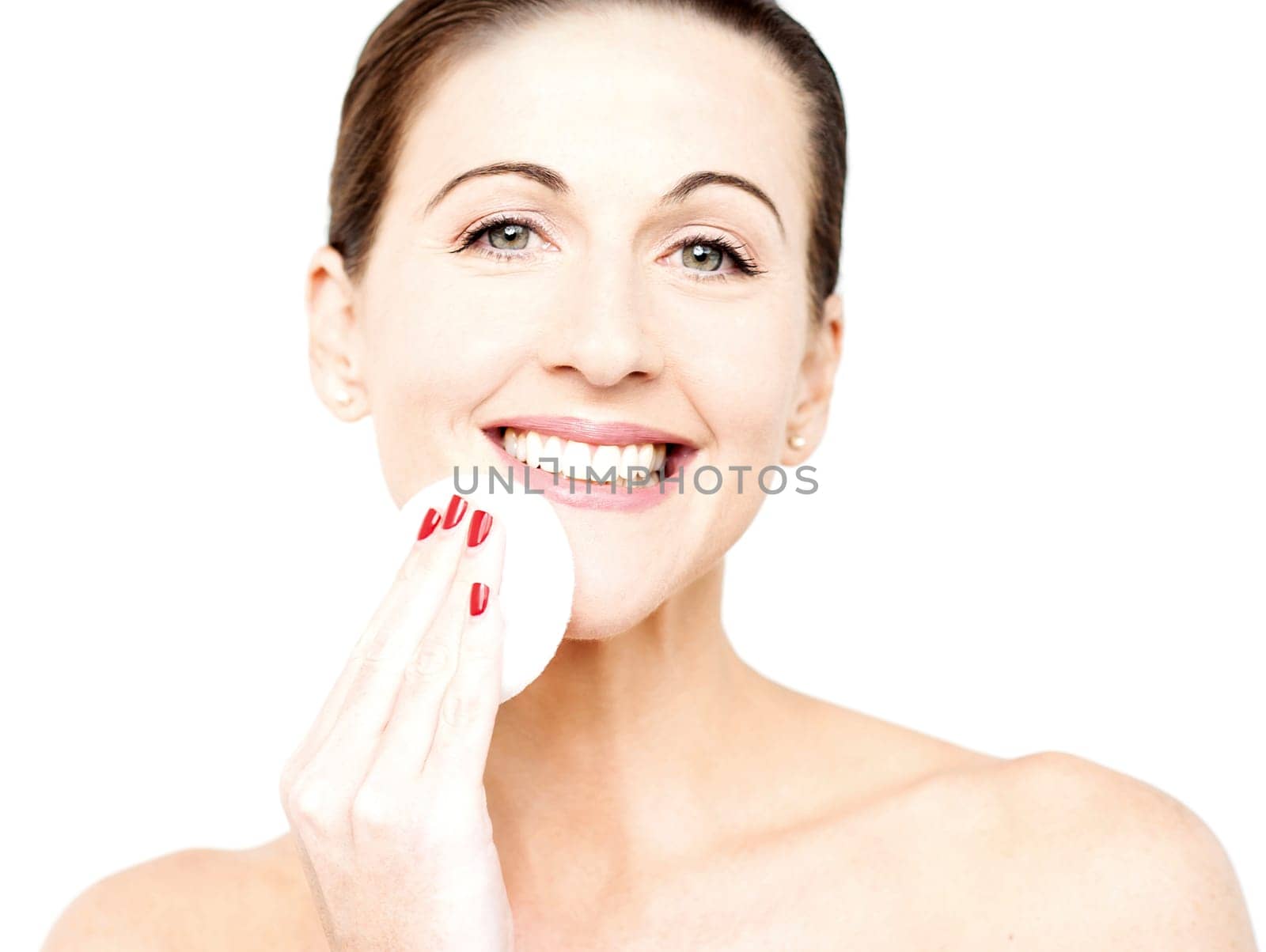 Beautiful woman cleaning her face with cotton after removing her make over