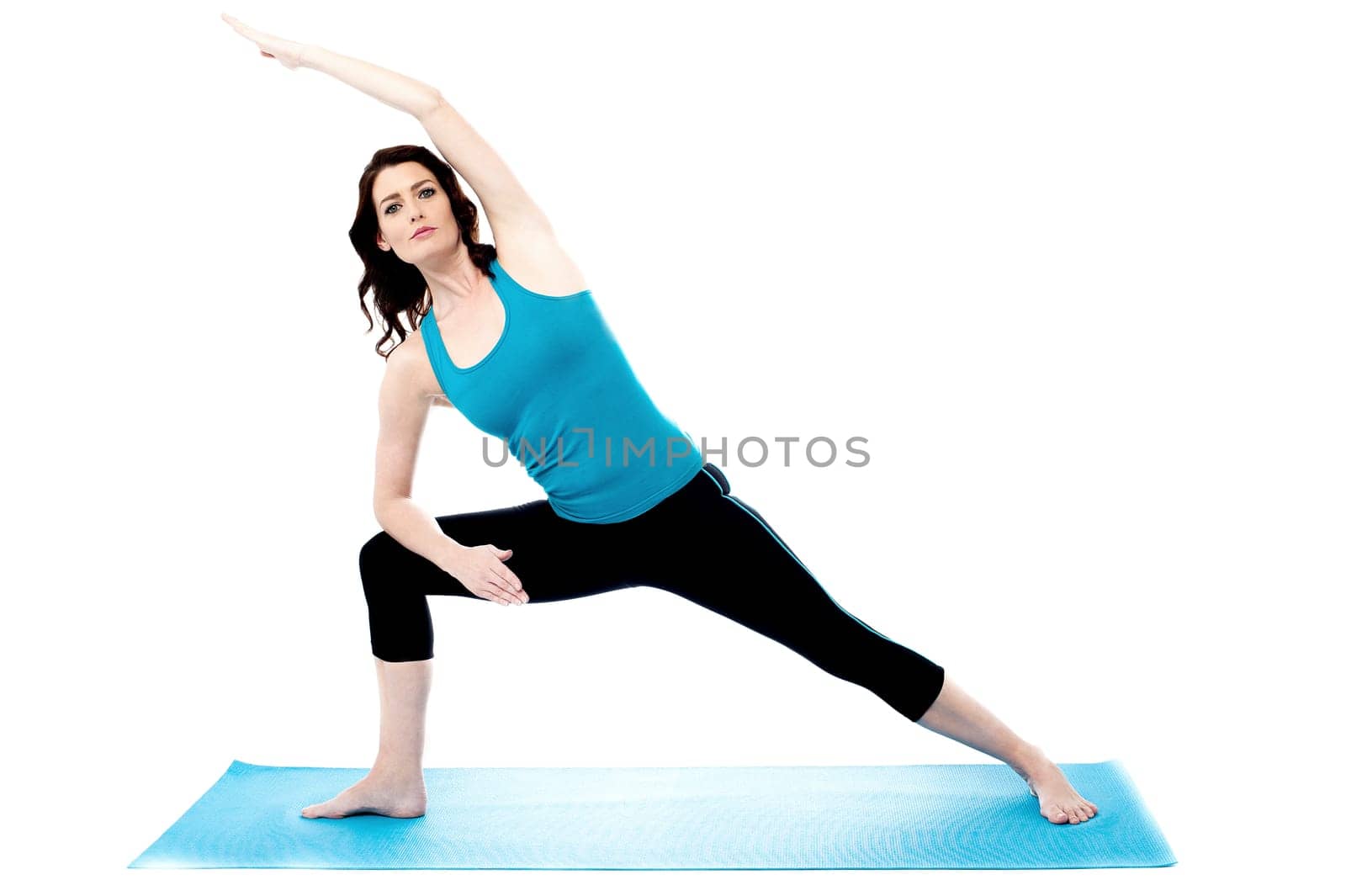 Young woman doing side stretch exercise on mat