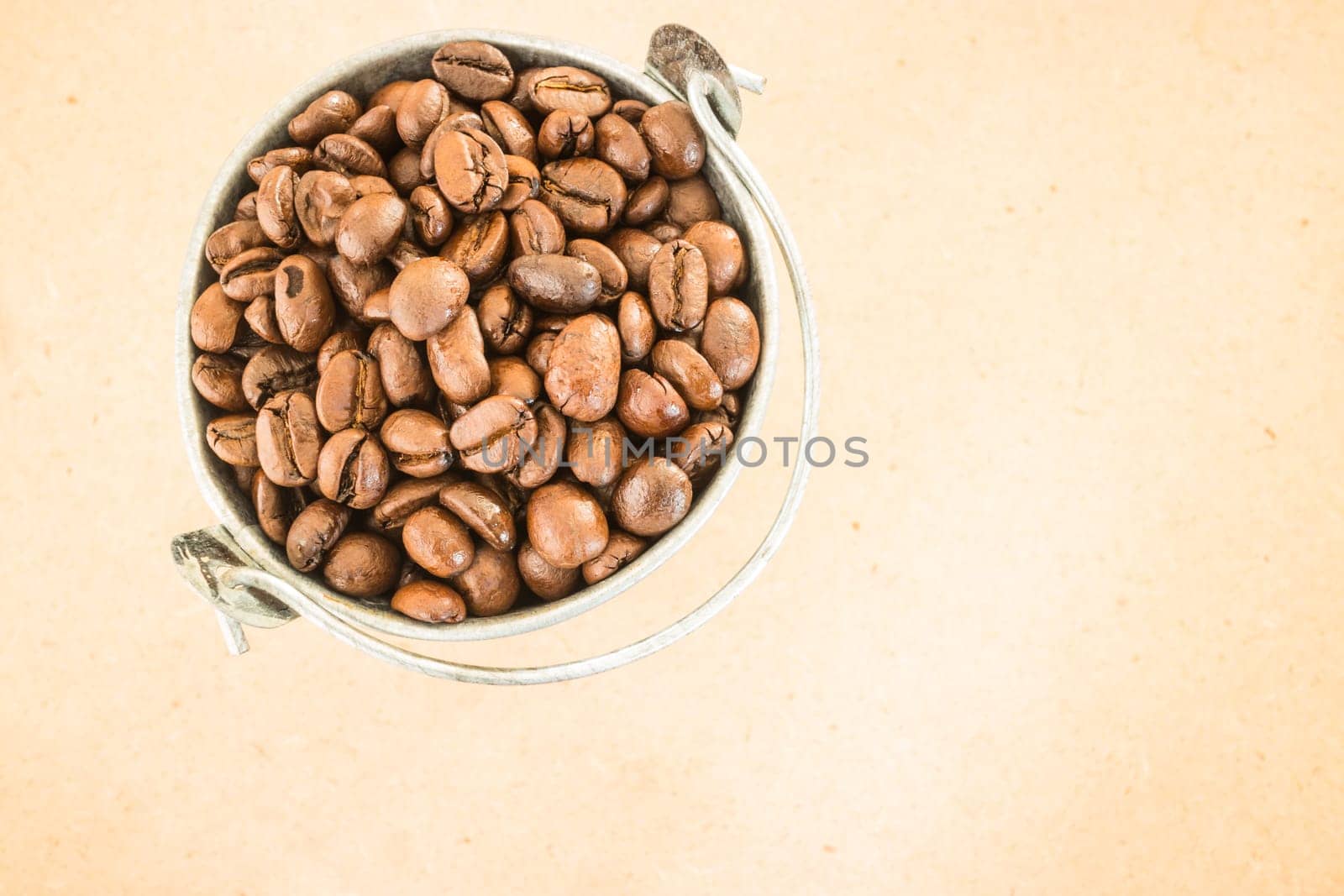 Coffee roasted bean in the bucket on wooden background, stock photo