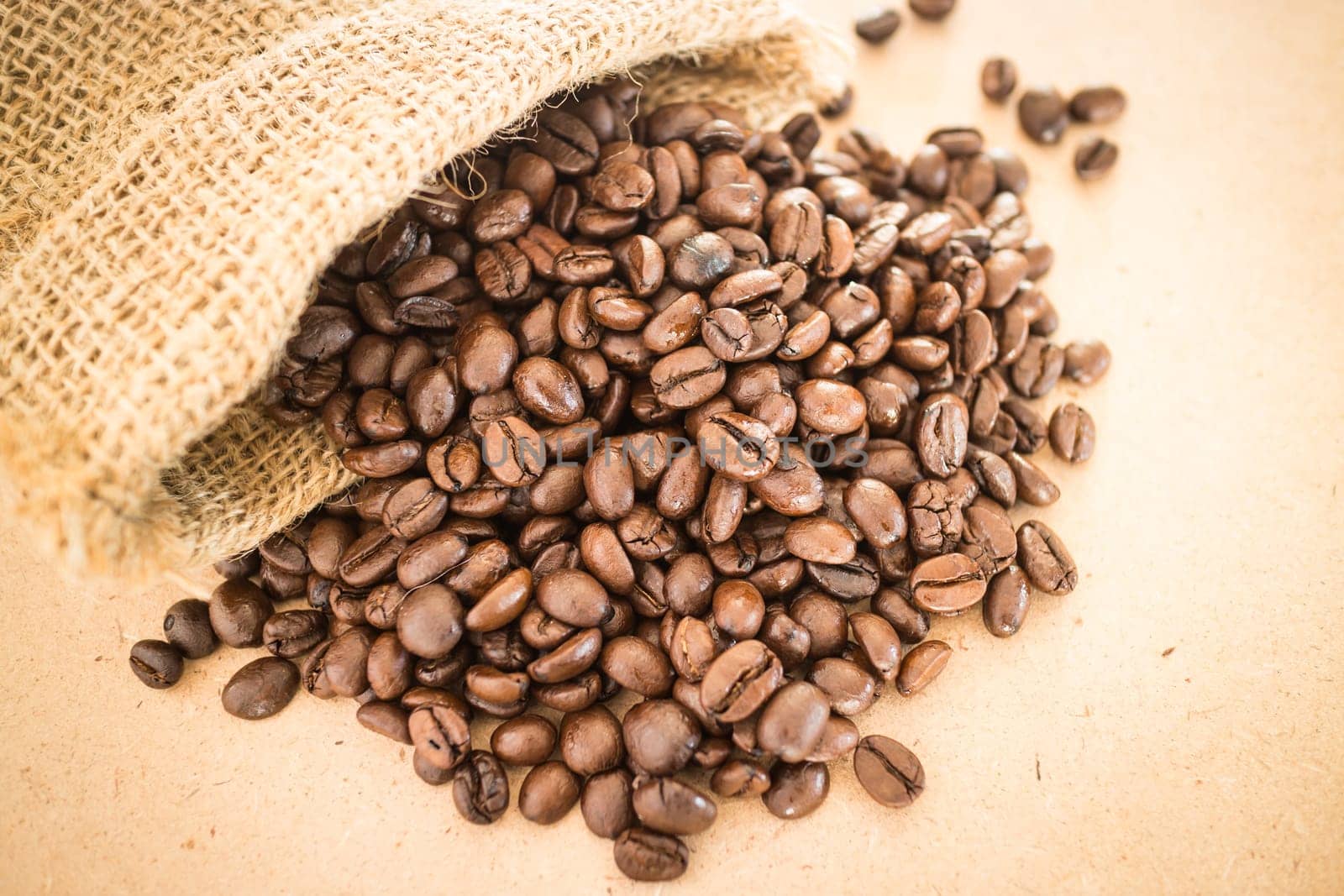 Coffee roasted bean in the sack on wooden background, stock photo