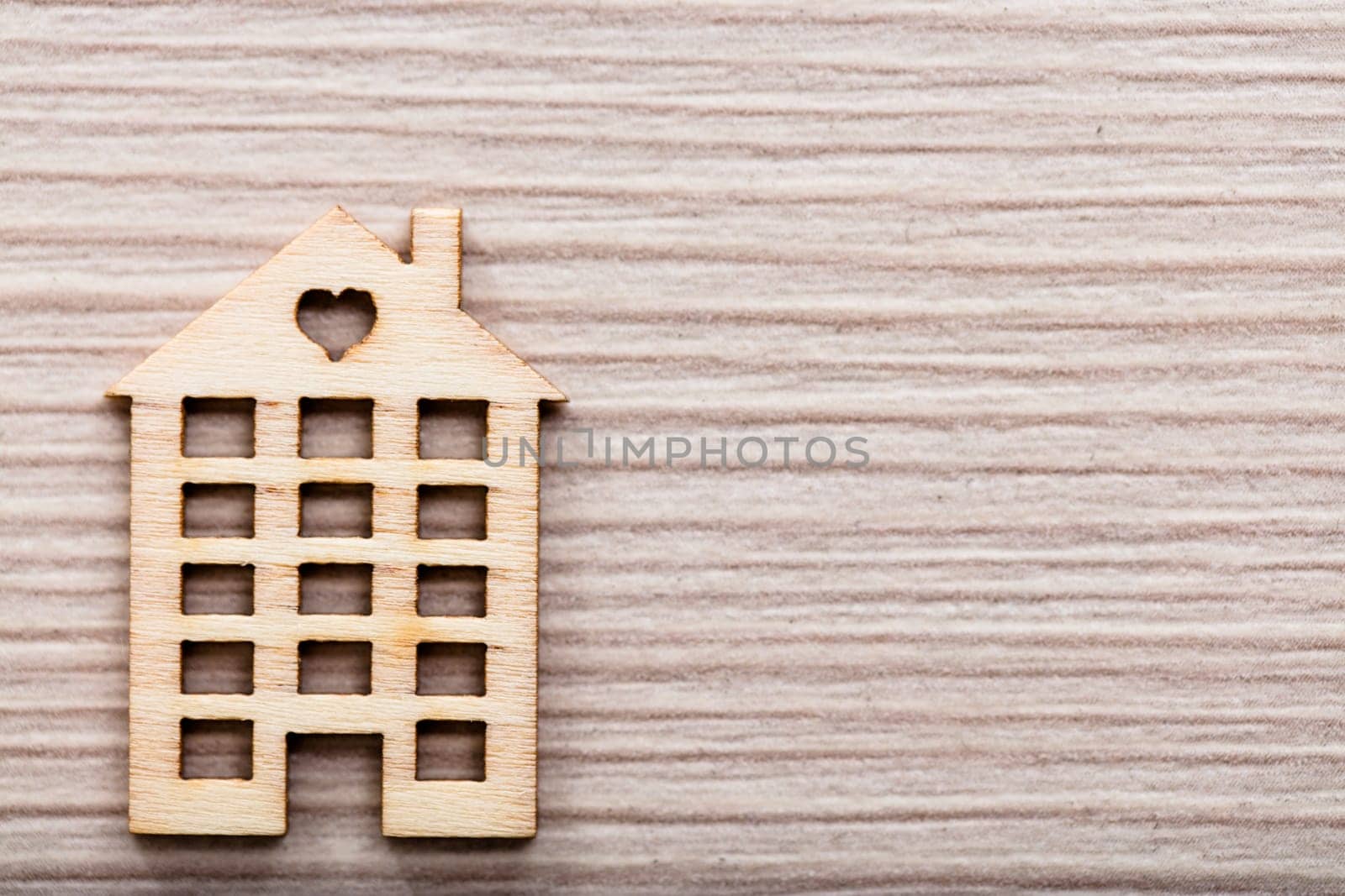 little wooden house with an heart on a wooden background ideal as background or wallpaper
