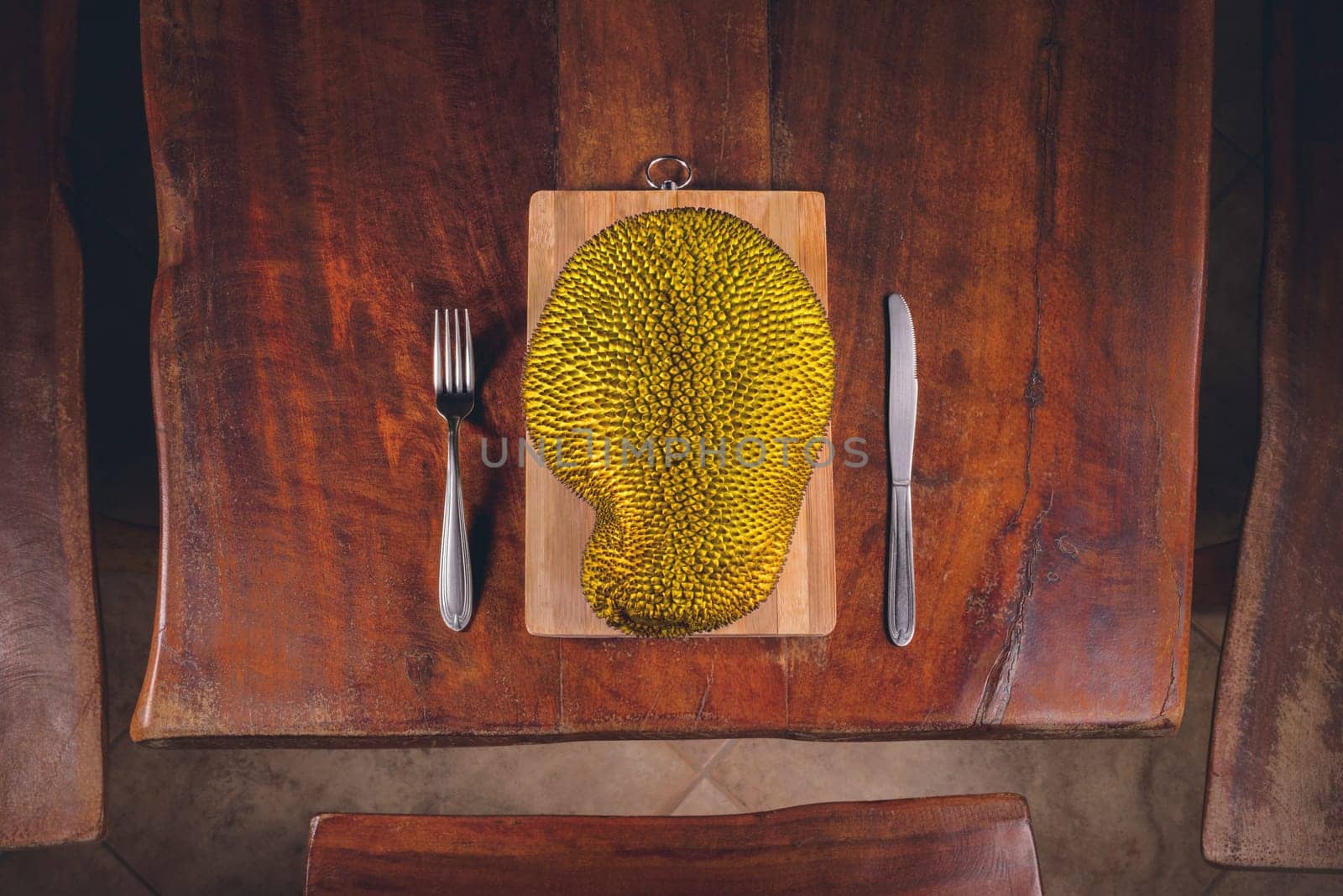 Fruit jackfruit on the table and cutlery around it.
