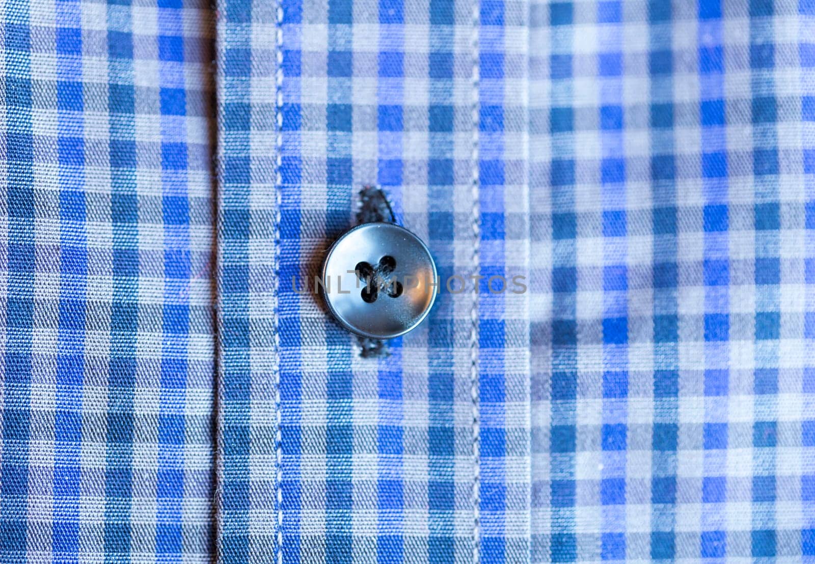 Shirt Button Close Up on blue and white shirt.