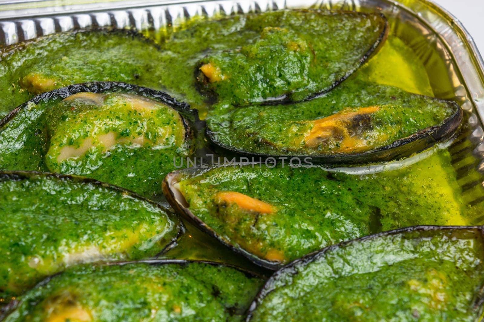 Mussels with garlic sauce in an aluminium bowl.