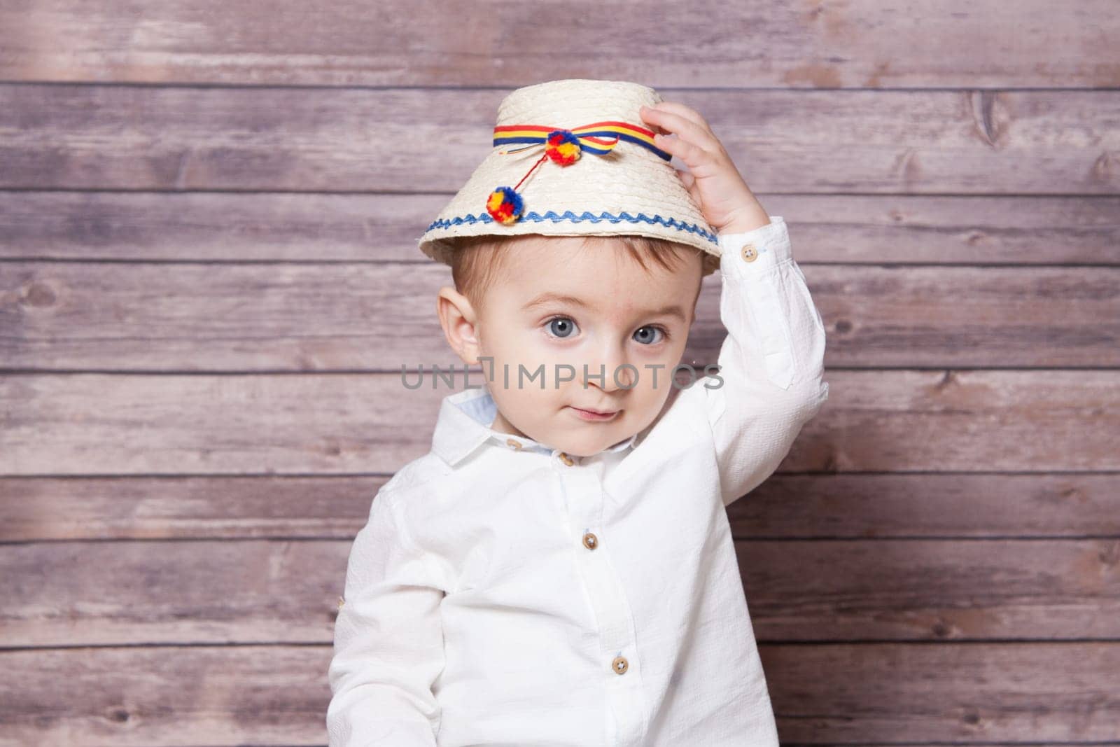 Portrait of a 1 year old baby boy wearing a Romanian traditional hat.