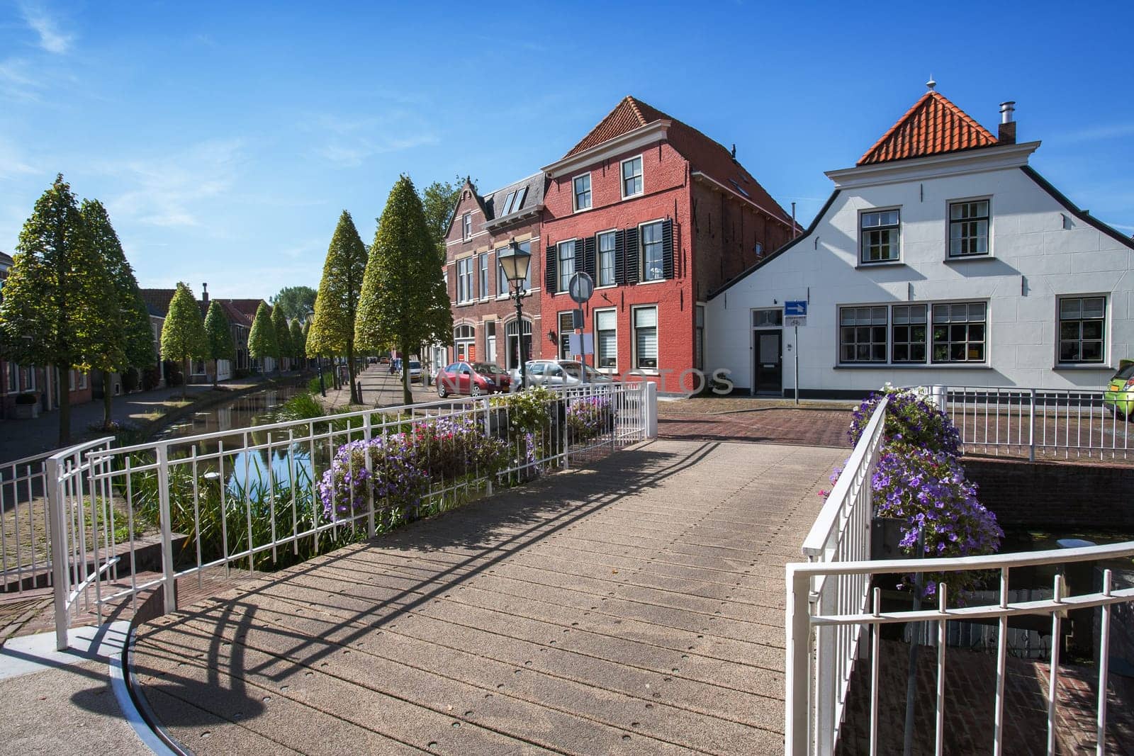Village street and a small bridge with flowers in the Netherlands