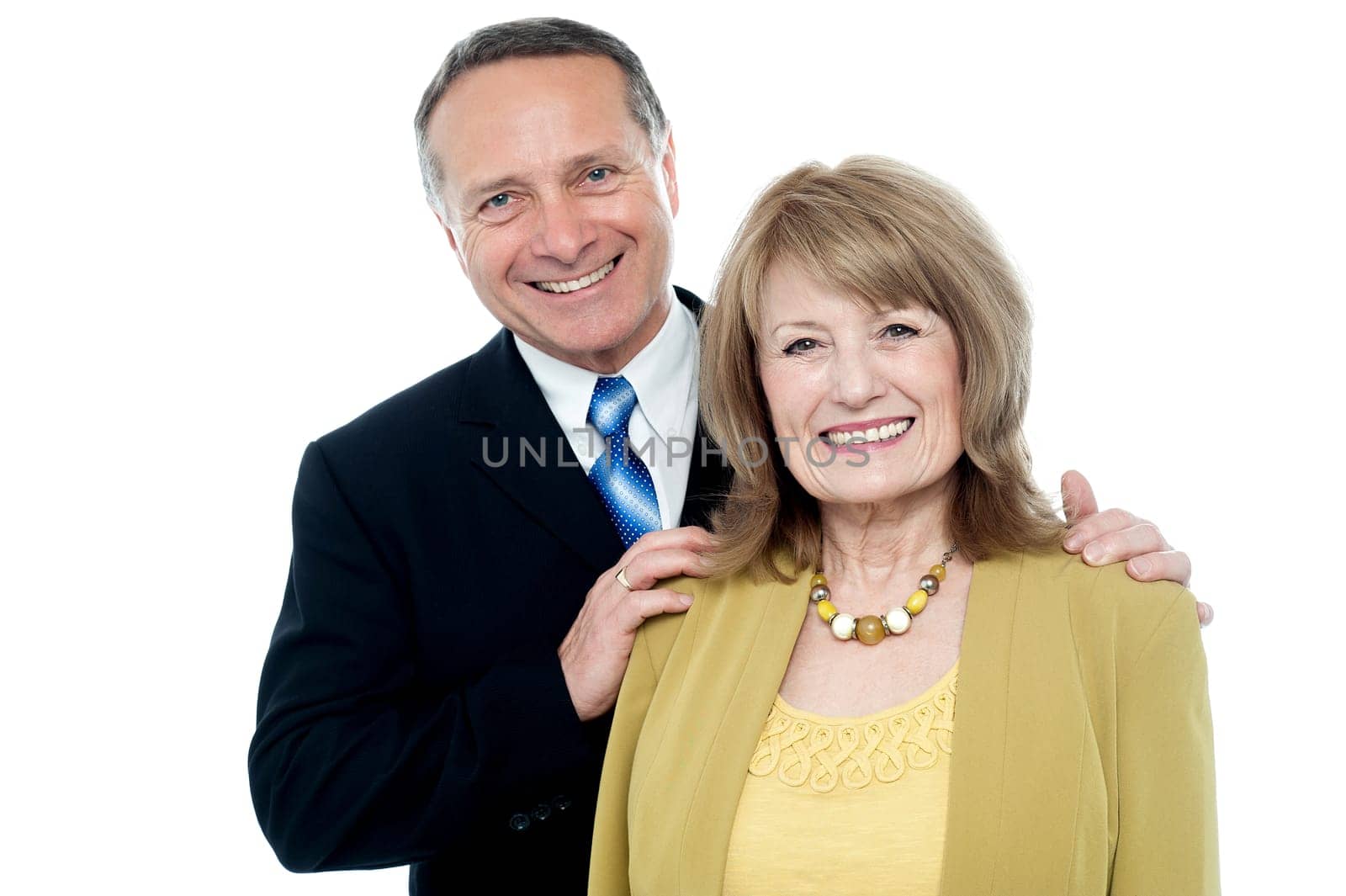Loving elderly couple smiling at camera over white