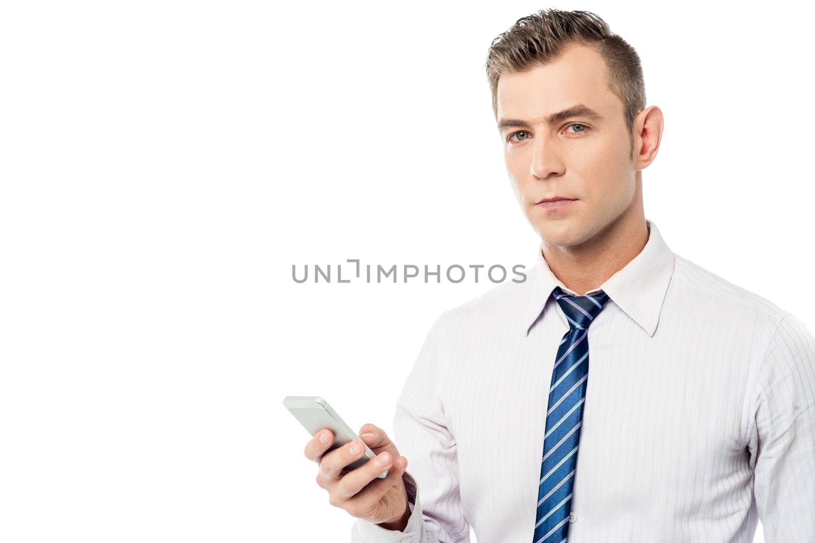 Young business professional posing with his mobile phone over white