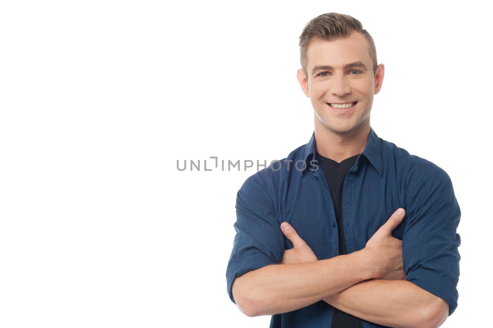 Smiling young causal guy posing with folded arms