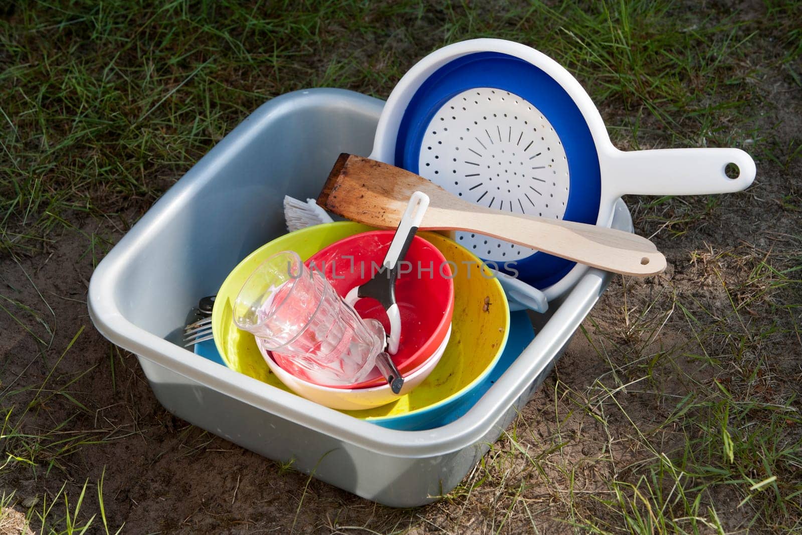Dirty dishes in a plastic bowl on the camping