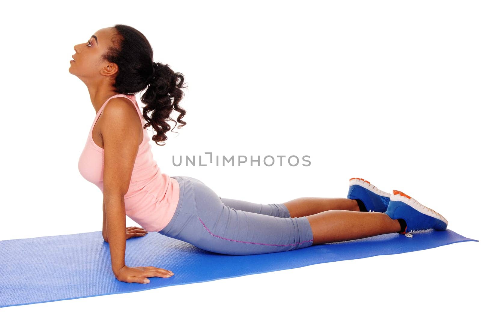 A young African American girl lying on a yoga mat, stretching her body, .in blue tights, isolated for white background..