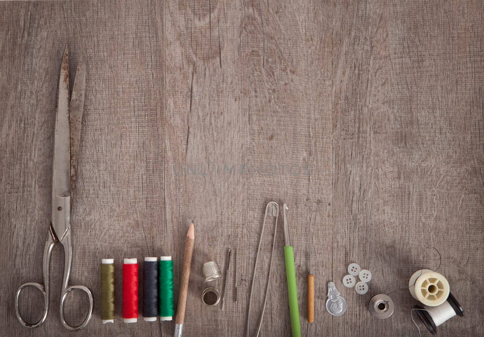 colorful fabrics and accessories for cutting lie on a wooden ground