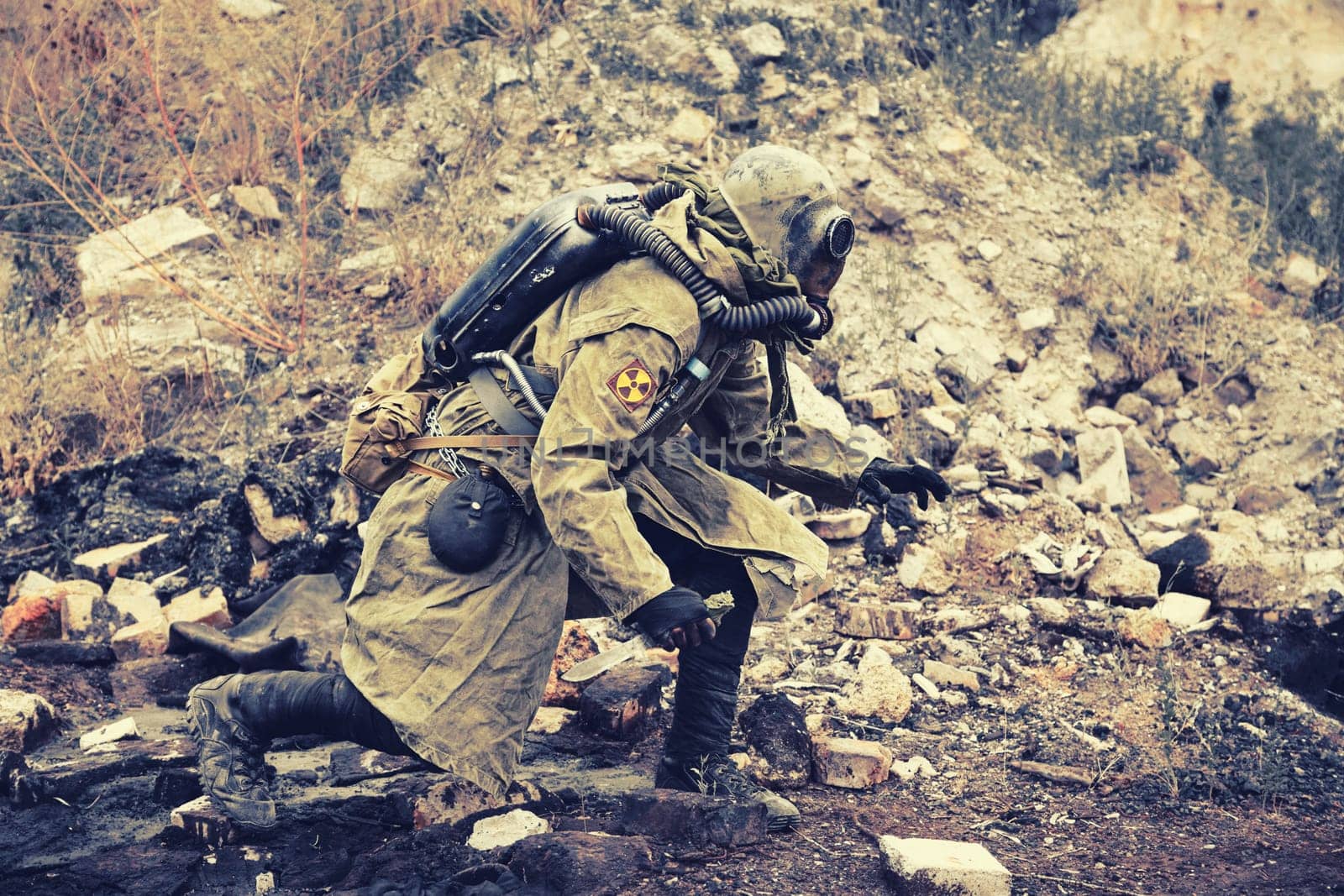 Post apocalypse. Sole survivor in tatters and gas mask on the ruins of the destroyed city