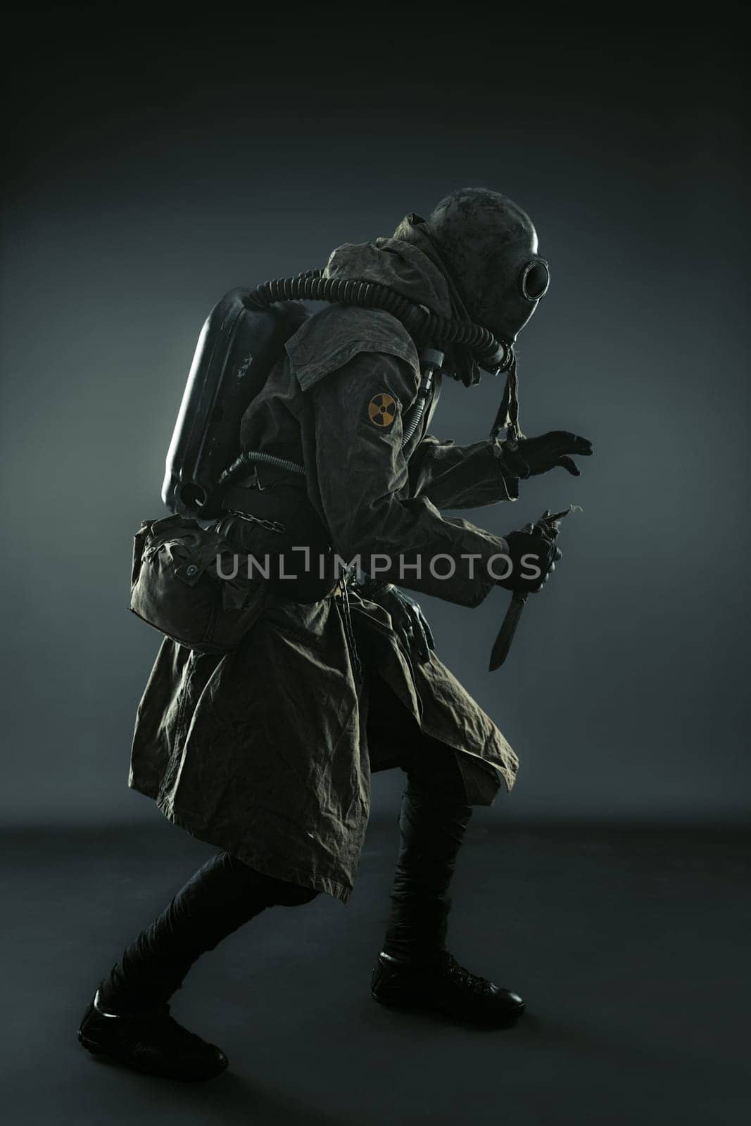 Nuclear post apocalypse. Studio shot of survivor in tatters and gas mask