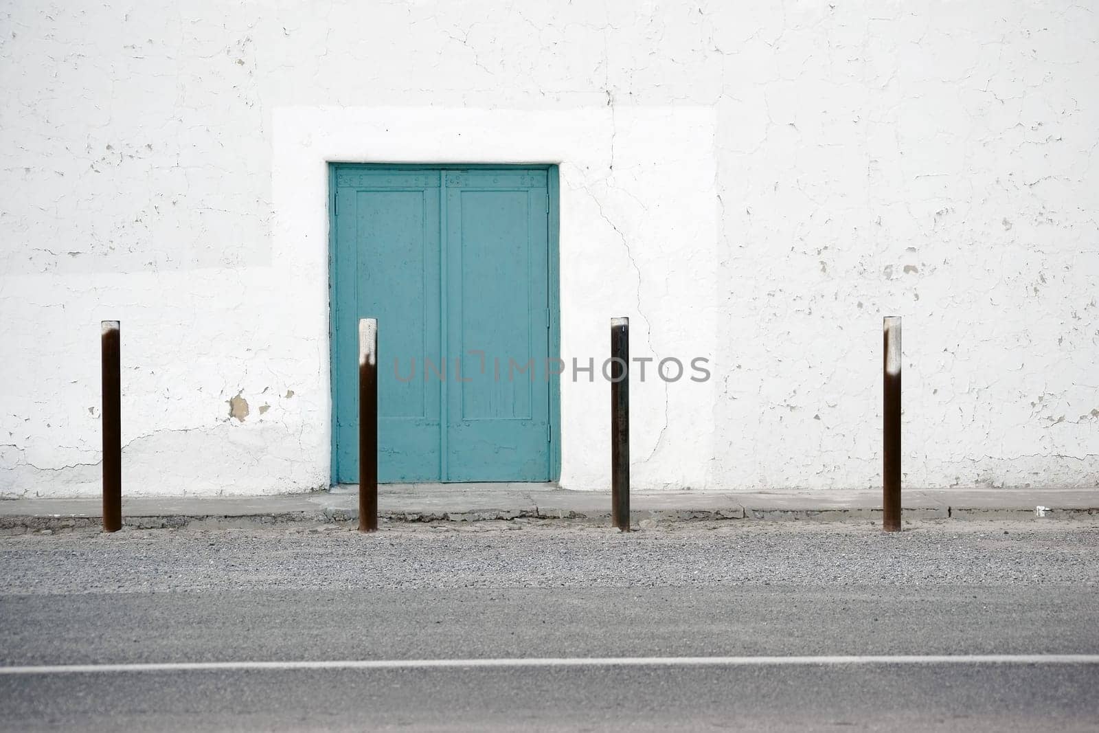 The side entrance of an old Spanish-style theatre with white plaster layers.