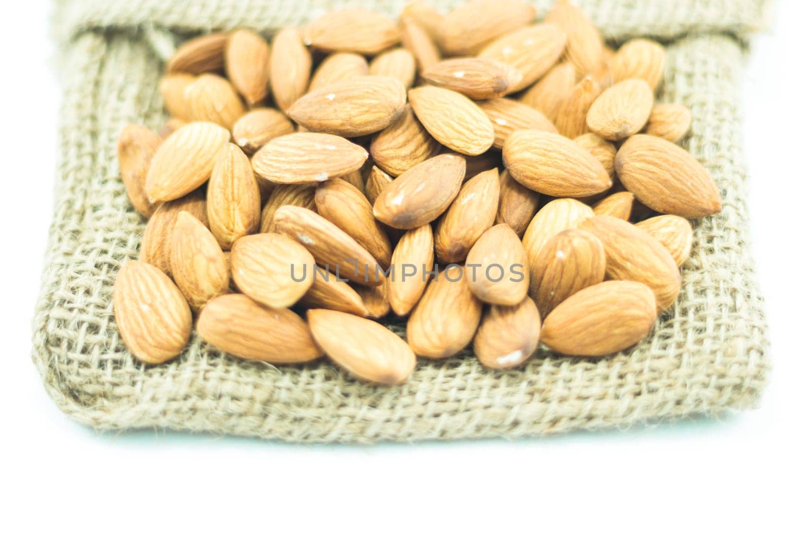 Almonds on the sack isolated on white background