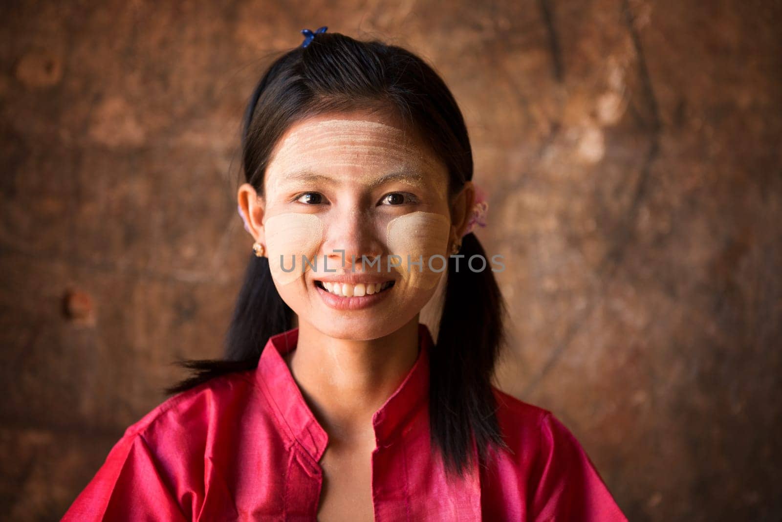 Young Myanmar female with Thanaka, a yellowish-white paste made from ground bark and used as a cosmetic and for sunburn protection.