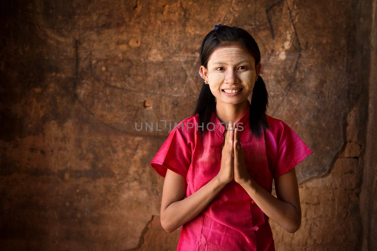 Young Myanmar woman in a traditional welcoming gesture.