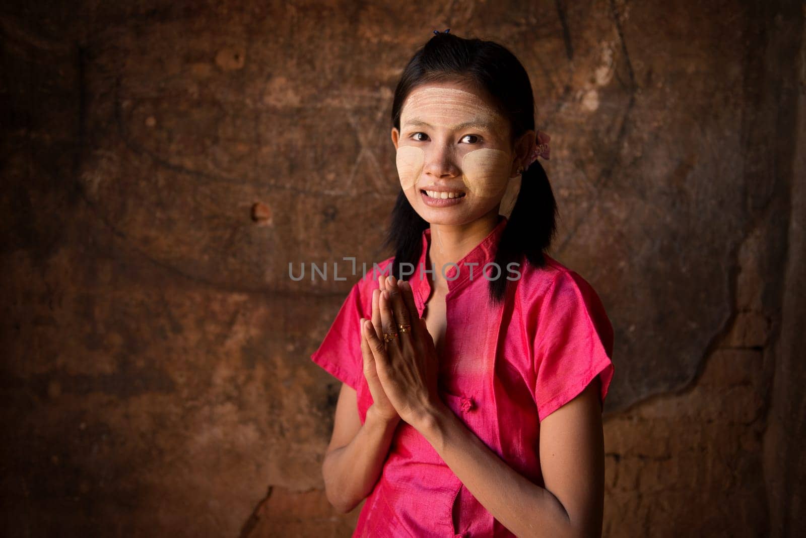 Young Myanmar girl in a traditional welcoming gesture.