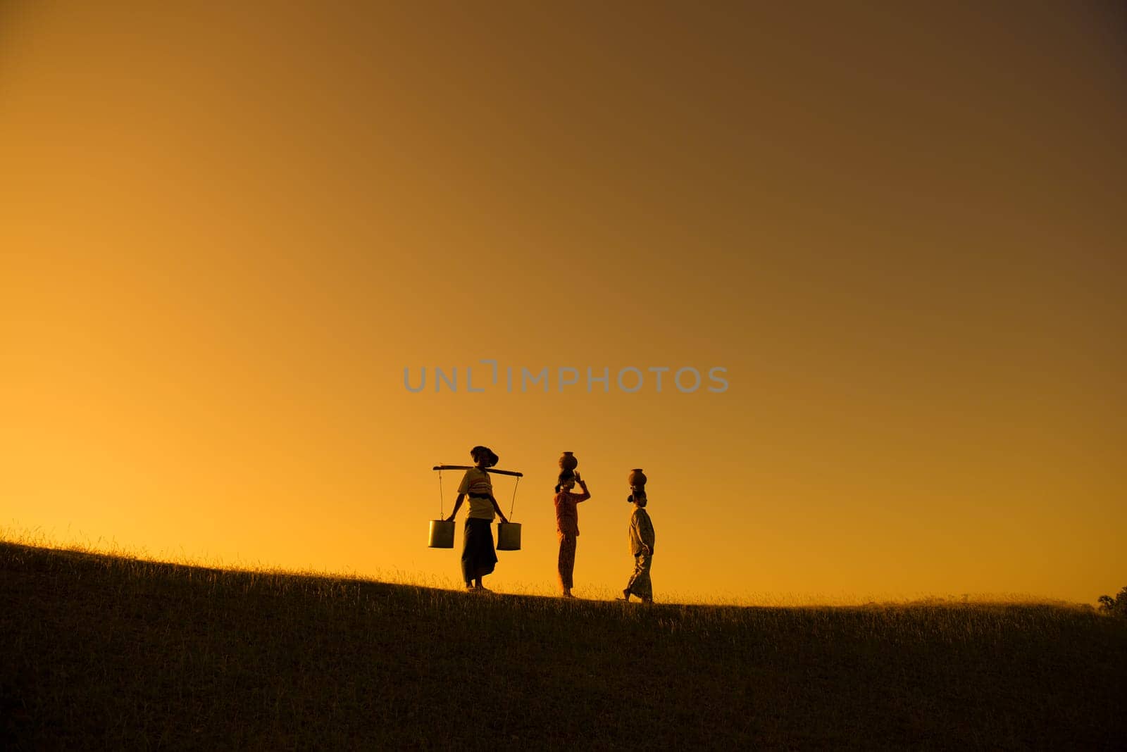 Silhouette of group Asian traditional farmers carrying clay pots on head going back home, Bagan, Myanmar