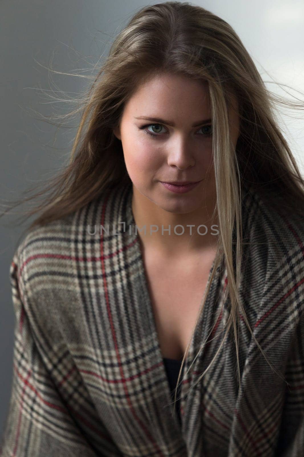 Close up portrait of an attractive young woman. She has a patterned scarf round her and is looking at the camera.