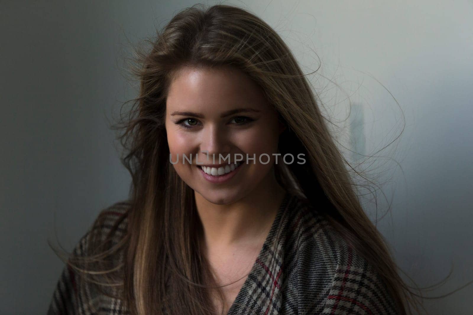 Close up portrait of an attractive young woman. She has a patterned scarf round her and is looking at the camera.