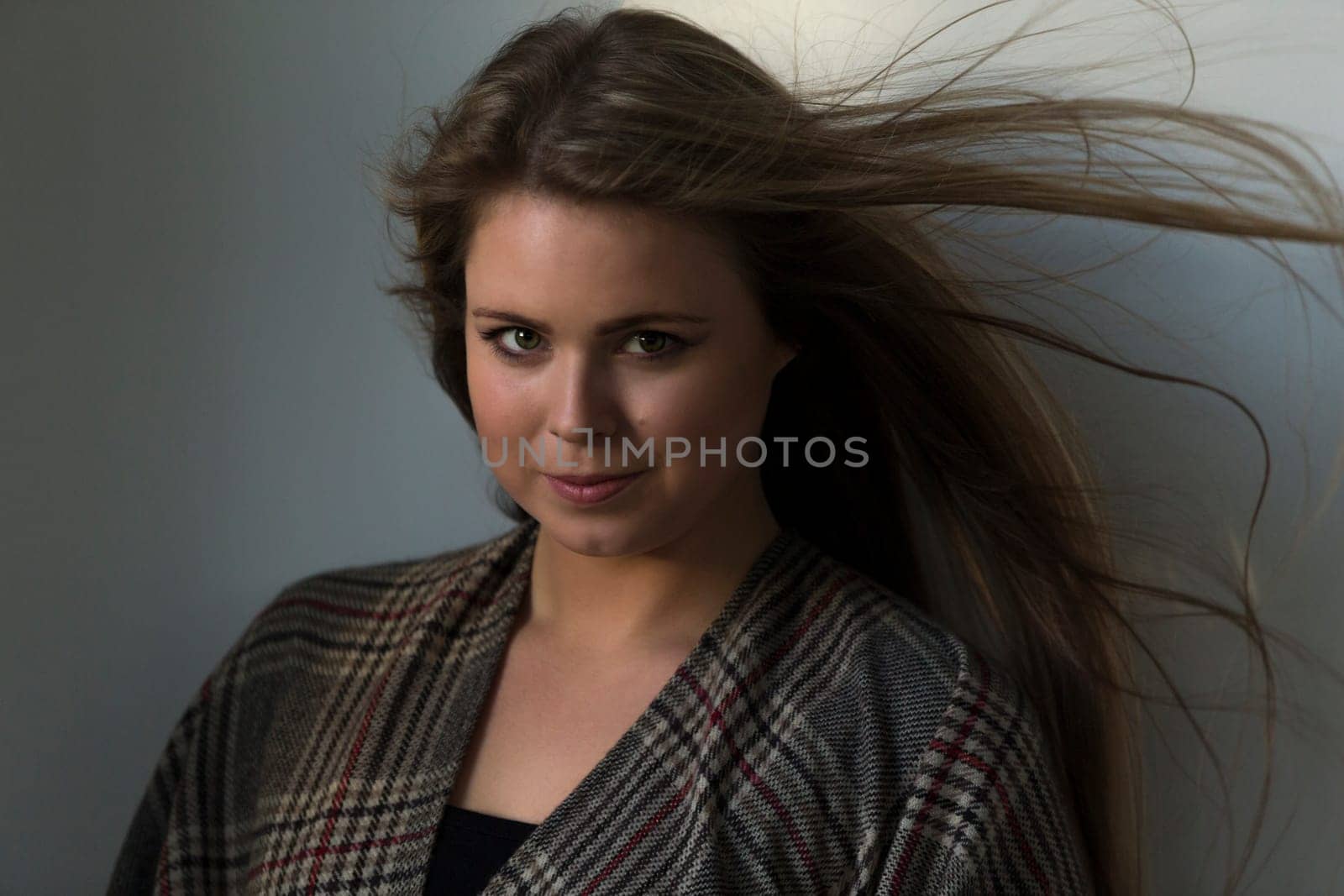 Close up portrait of an attractive young woman. She has a patterned scarf round her and is looking at the camera.