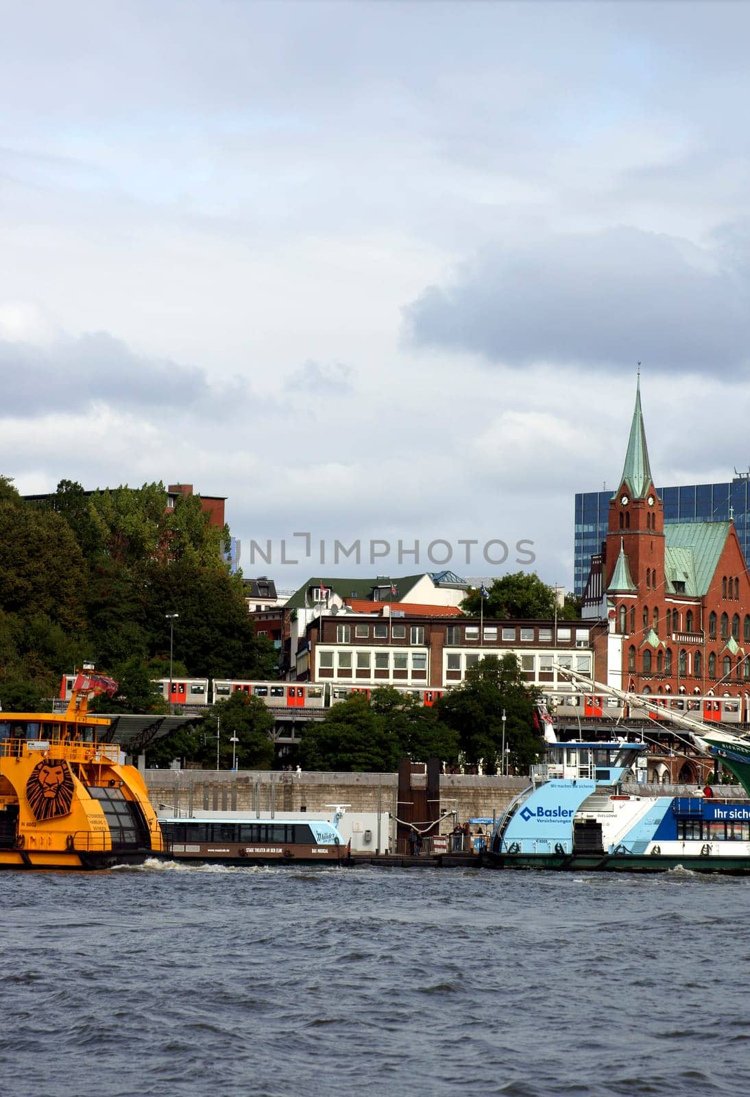 Hamburg,Germany – September 22,2014: A tram passes through the port of Hamburg with boats and sailing ships on September 22,2014 in Hamburg.