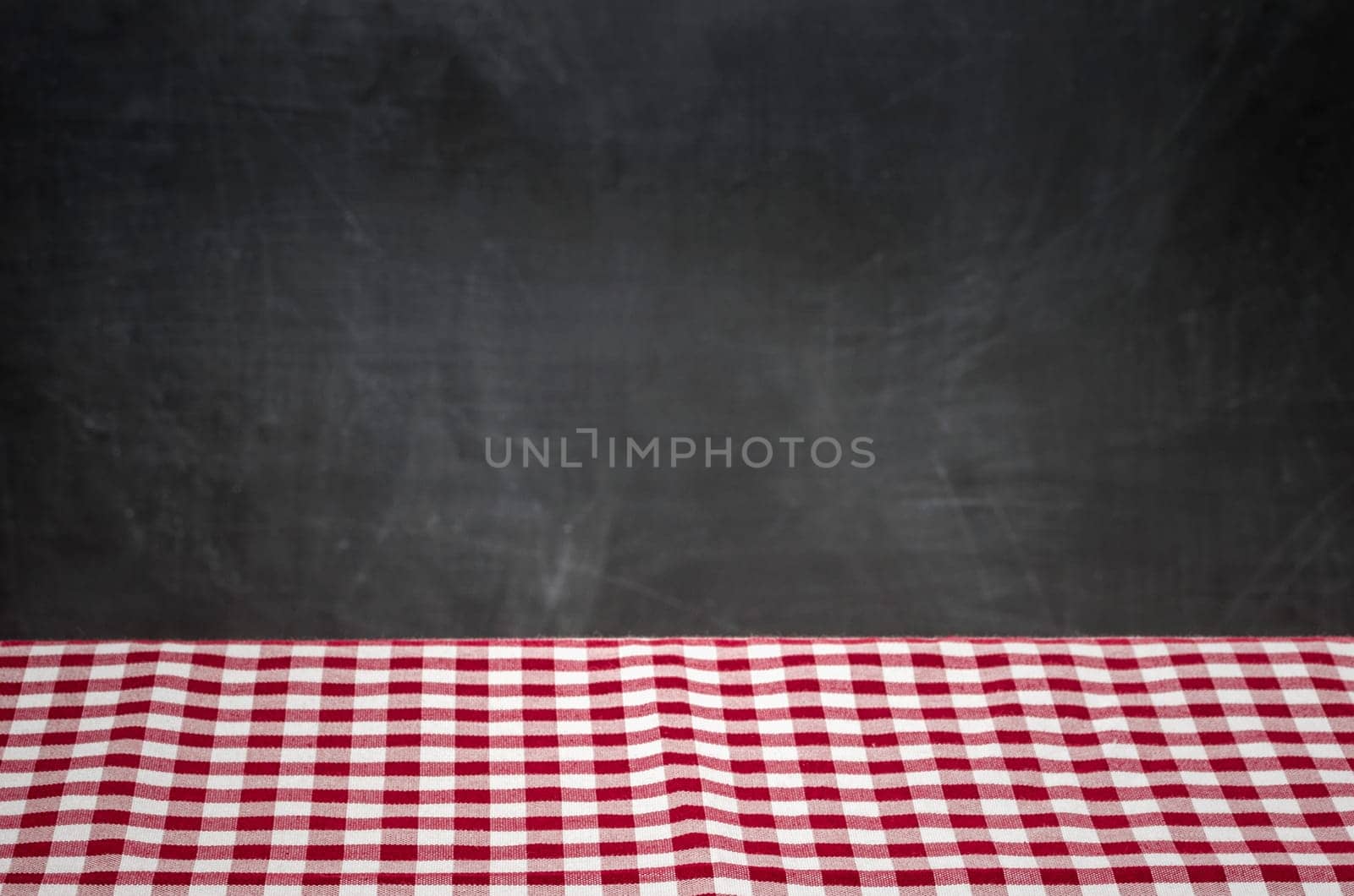 Red and white checkered tablecloth in front of black wall panel