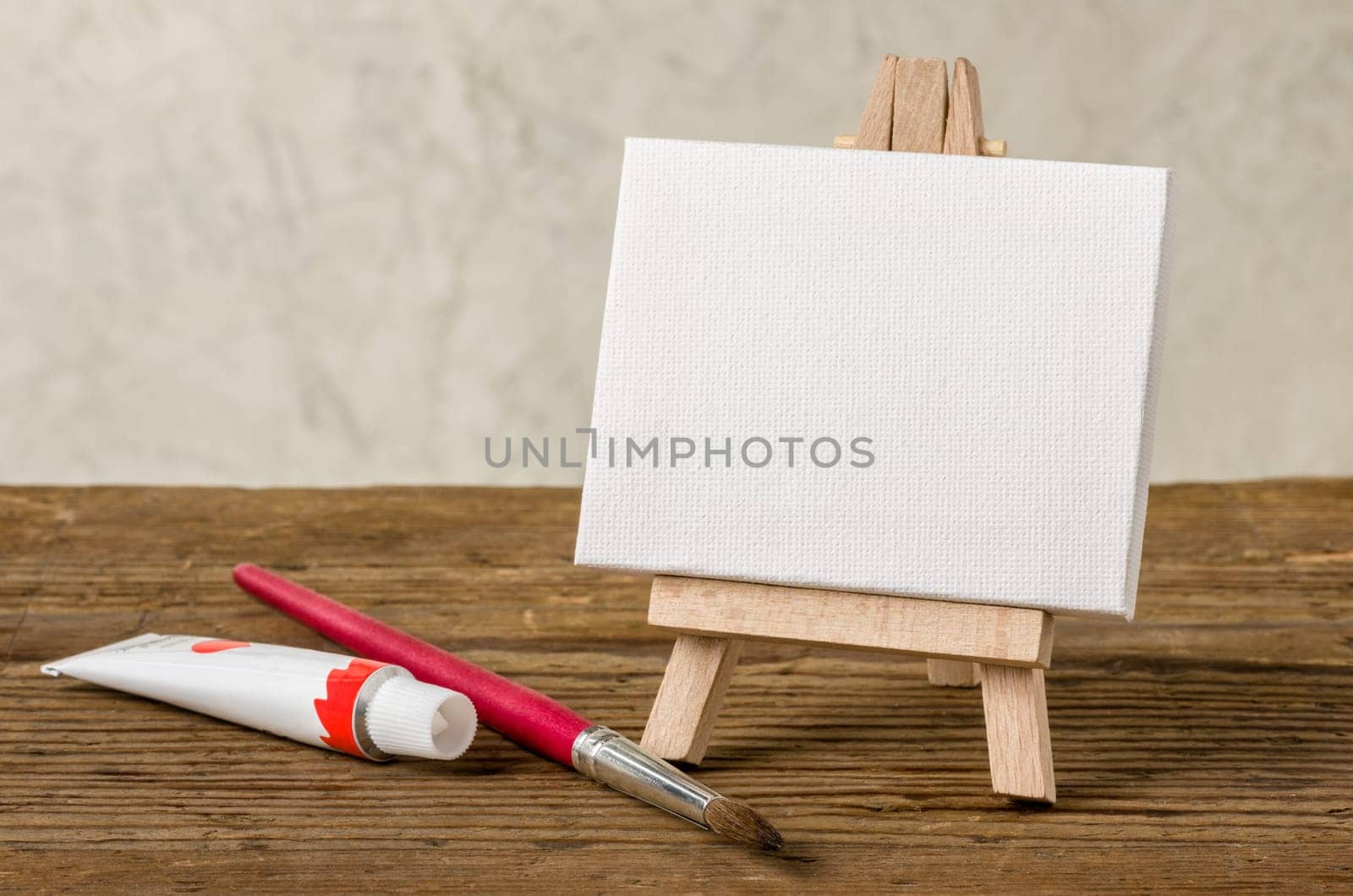 Easel with blank canvas,paint tube and brush