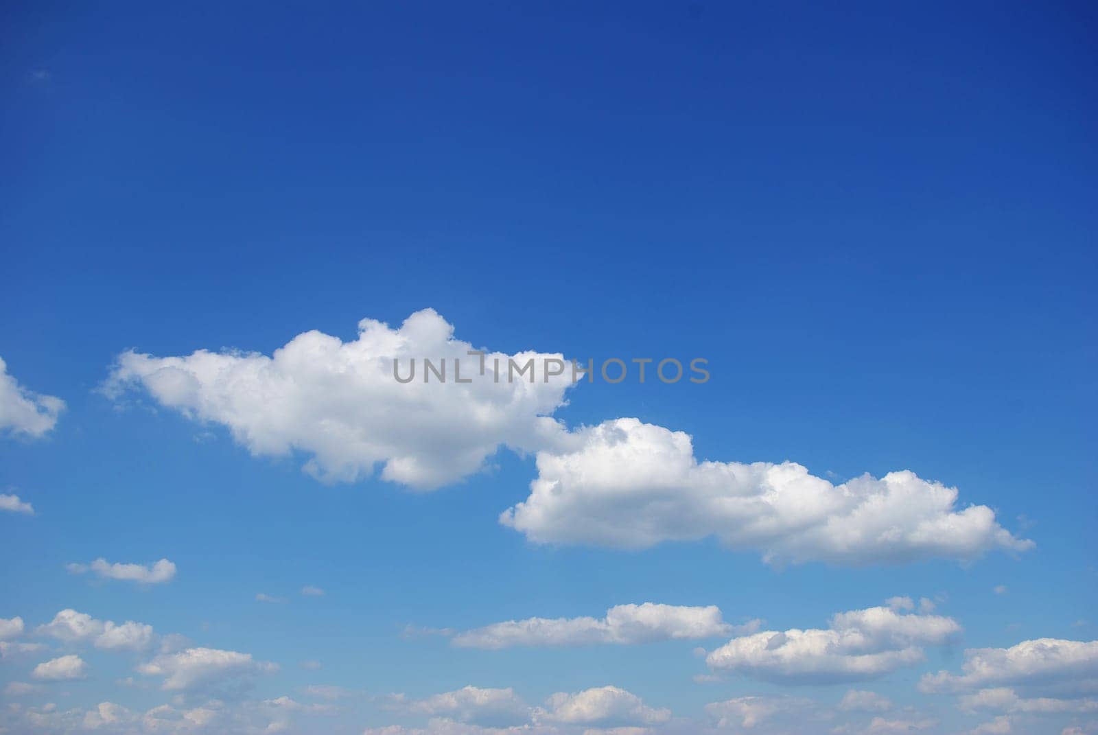 Blue sky background with tiny clouds
