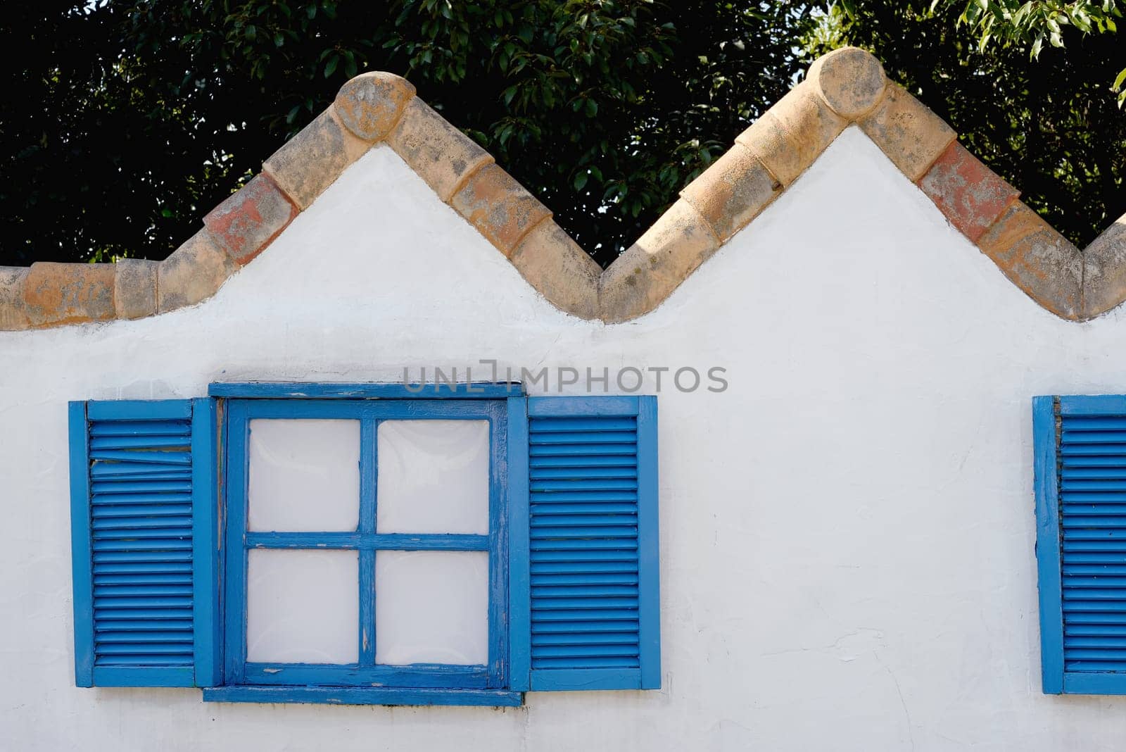 wooden window on the white wall with weathered wooden shutter