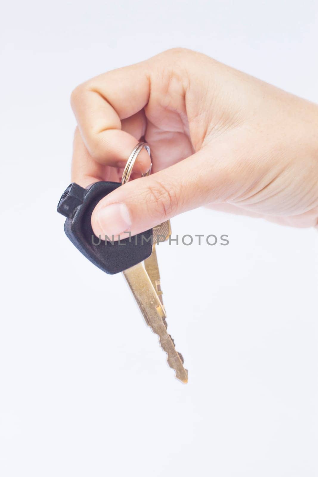 Hand with a car key isolated on white background, stock photo