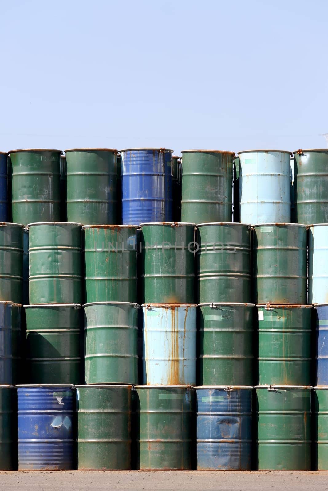 Stack of oil barrels against a blue sky