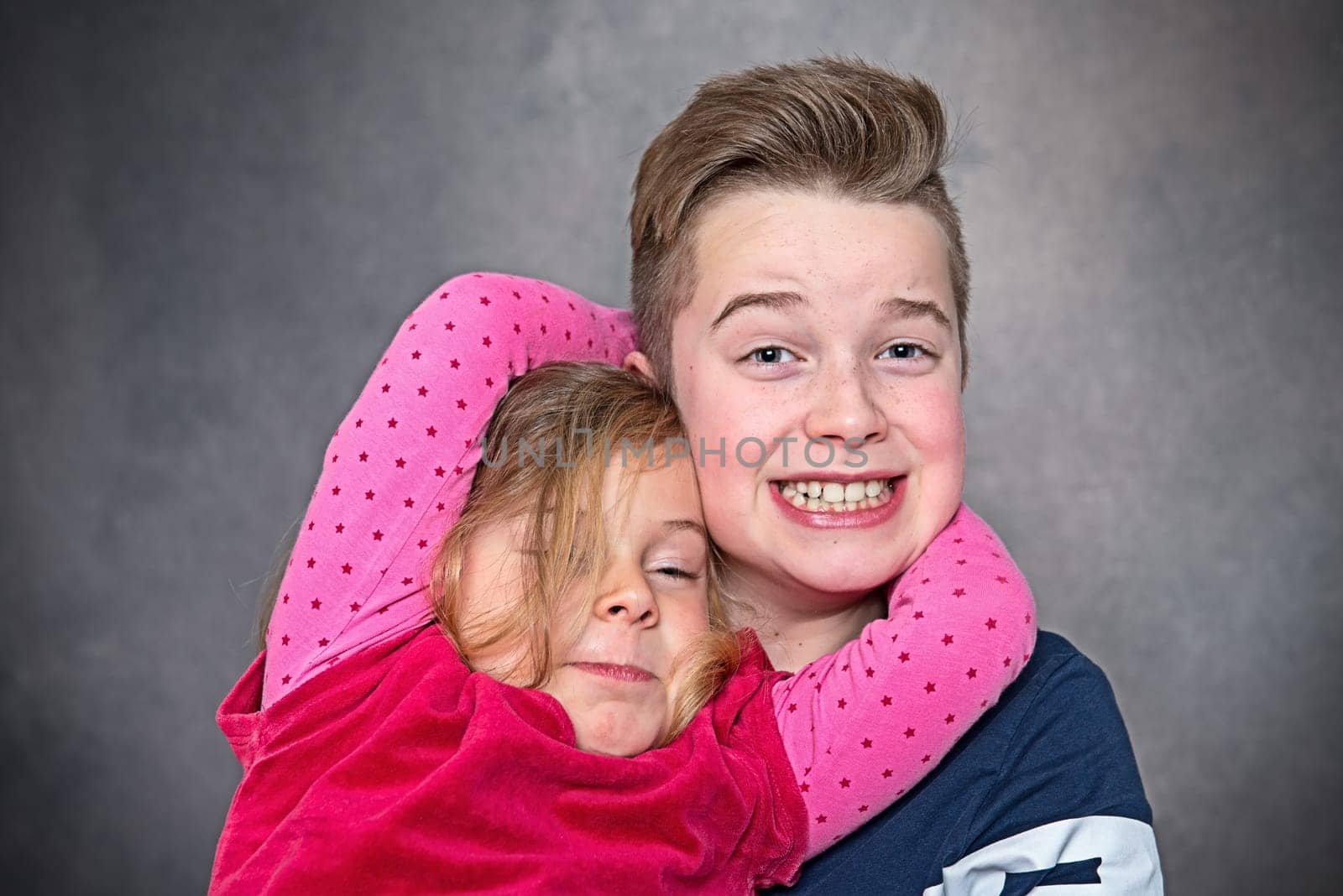 brother and sister together in front of gray background